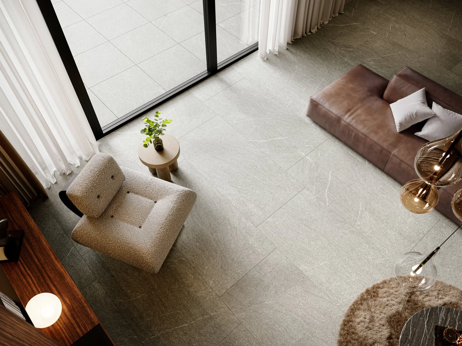 Vista cenital de una estancia con piso de porcelanato gris, sillón bouclé y mesa auxiliar