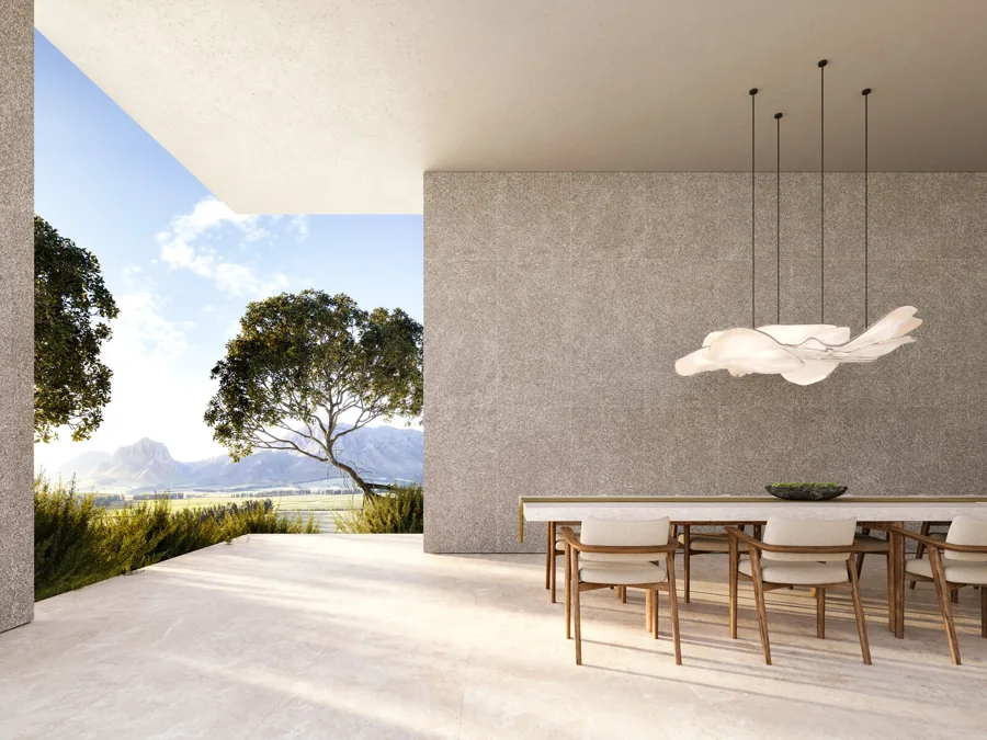 Terraza techada con comedor y muro de piedra gris